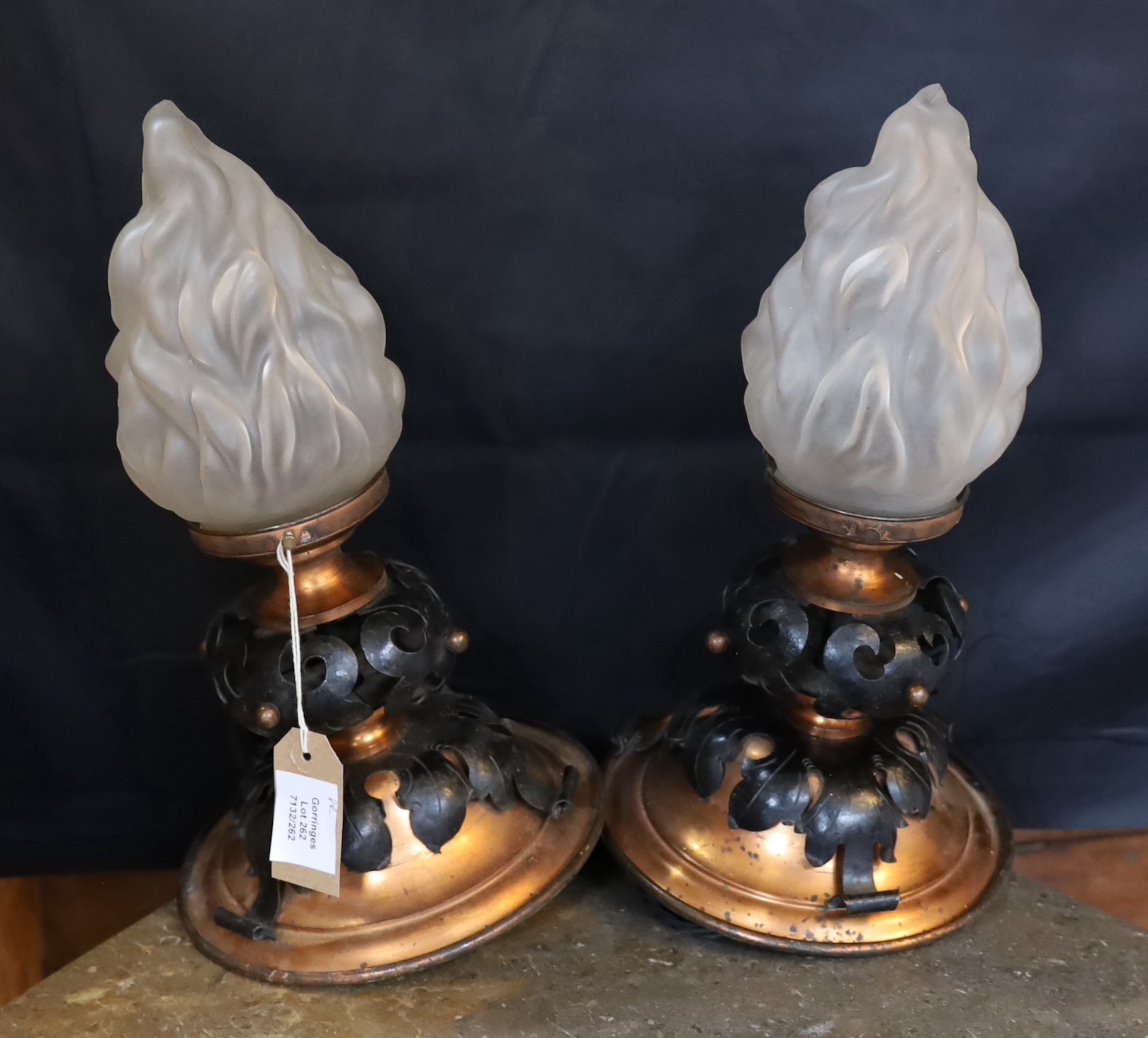 A pair of French Arts & Crafts copper and wrought iron ceiling lights with flambeau frosted glass shades, height 37cm. width 21cm